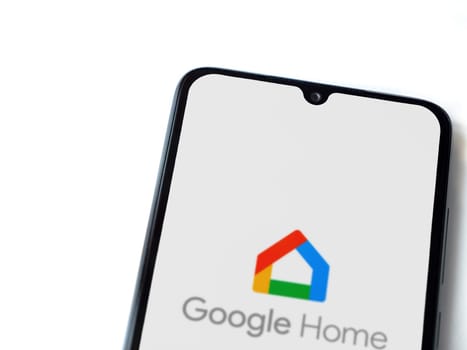 Lod, Israel - July 16,2023: Google Home app launch screen on smartphone on white background. Top view flat lay with copy space.