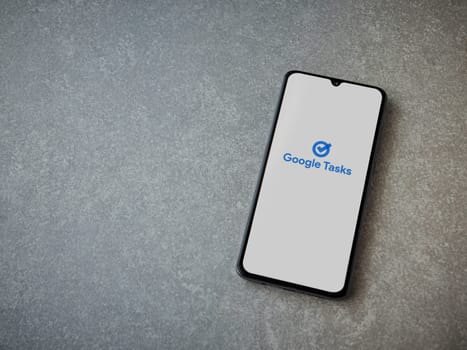 Lod, Israel - July 16,2023: Google Task app launch screen on smartphone on ceramic stone background. Top view flat lay with copy space.