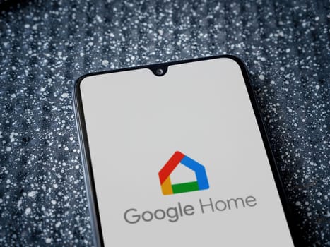Lod, Israel - July 16,2023: Google Home app launch screen on smartphone on metallic background. Close up top view flat lay.