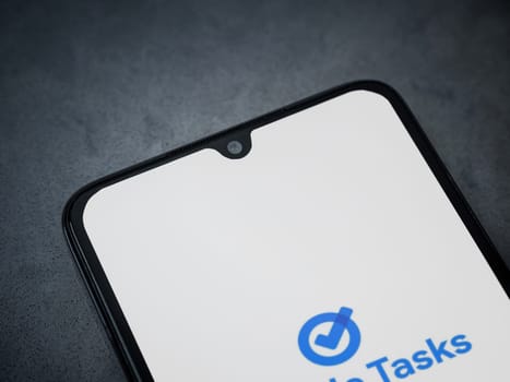 Lod, Israel - July 16,2023: Google Task app launch screen on smartphone on dark marble stone background. Top view flat lay with copy space.