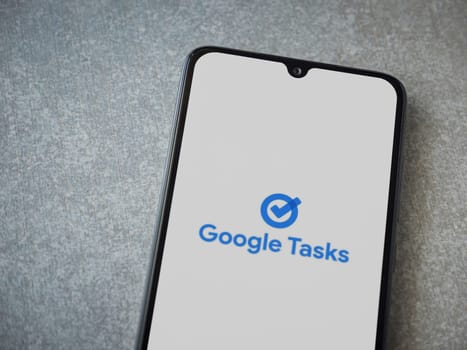 Lod, Israel - July 16,2023: Google Task app launch screen on smartphone on ceramic stone background. Top view flat lay with copy space.