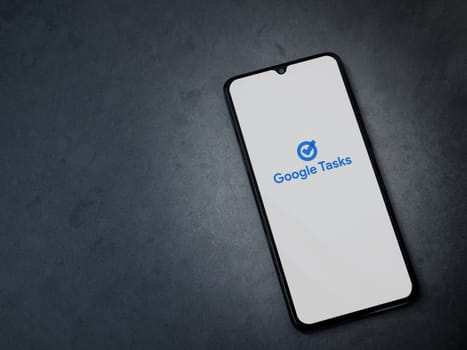 Lod, Israel - July 16,2023: Google Task app launch screen on smartphone on dark marble stone background. Top view flat lay with copy space.