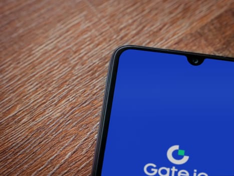 Lod, Israel - July 16,2023: Gate.io app launch screen on smartphone on wooden background. Top view flat lay with copy space.