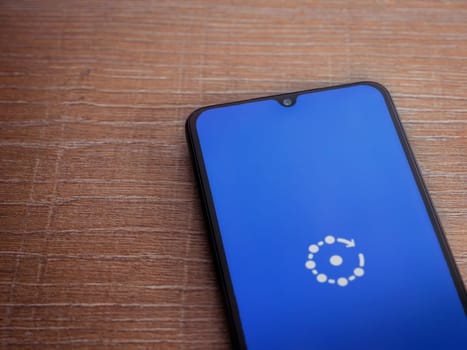 Lod, Israel - July 16,2023: Fing app launch screen on smartphone on wooden background. Top view flat lay with copy space.