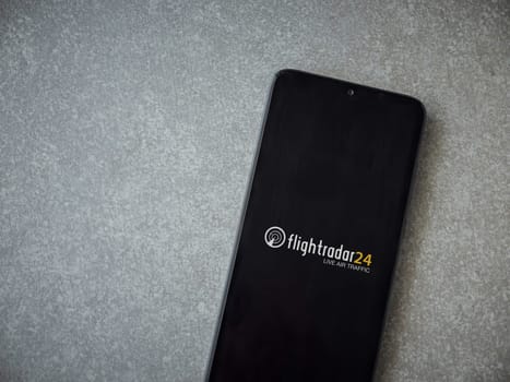 Lod, Israel - July 16,2023: Flightradar24 Flight Tracker app launch screen on smartphone on ceramic stone background. Top view flat lay with copy space.