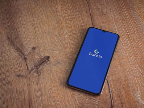 Lod, Israel - July 16,2023: Gate.io app launch screen on smartphone on wooden background. Top view flat lay with copy space.