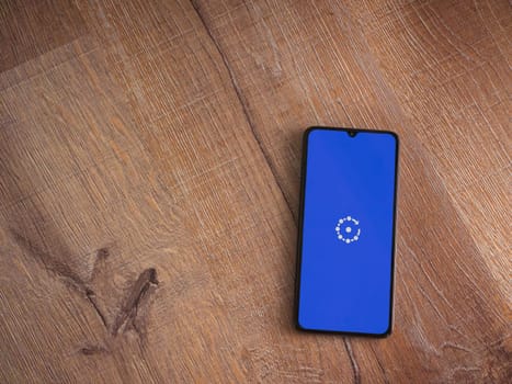 Lod, Israel - July 16,2023: Fing app launch screen on smartphone on wooden background. Top view flat lay with copy space.
