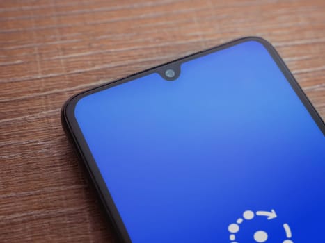 Lod, Israel - July 16,2023: Fing app launch screen on smartphone on wooden background. Top view flat lay with copy space.