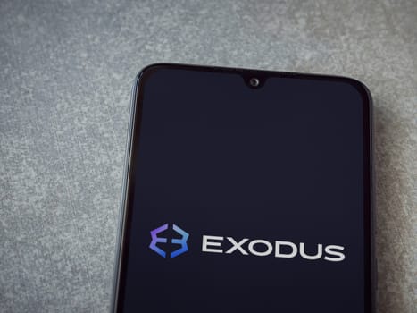 Lod, Israel - July 16,2023: Exodus app launch screen on smartphone on ceramic stone background. Top view flat lay with copy space.