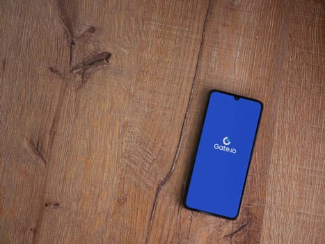 Lod, Israel - July 16,2023: Gate.io app launch screen on smartphone on wooden background. Top view flat lay with copy space.