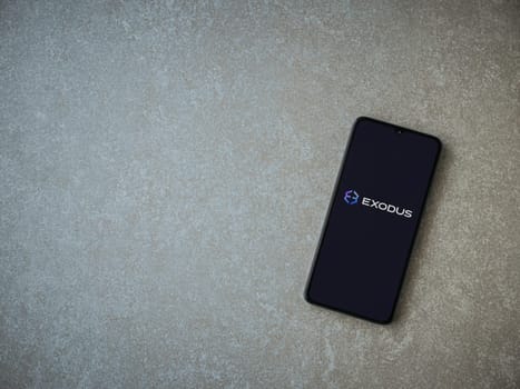 Lod, Israel - July 16,2023: Exodus app launch screen on smartphone on ceramic stone background. Top view flat lay with copy space.