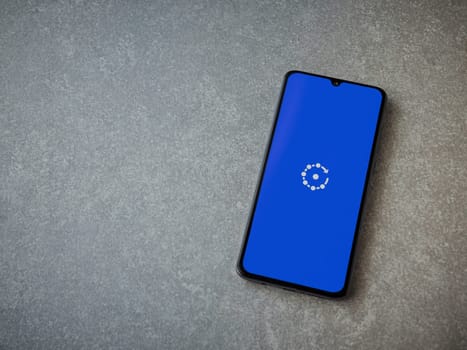 Lod, Israel - July 16,2023: Fing app launch screen on smartphone on ceramic stone background. Top view flat lay with copy space.