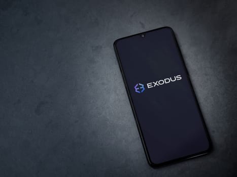 Lod, Israel - July 16,2023: Exodus app launch screen on smartphone on dark marble stone background. Top view flat lay with copy space.