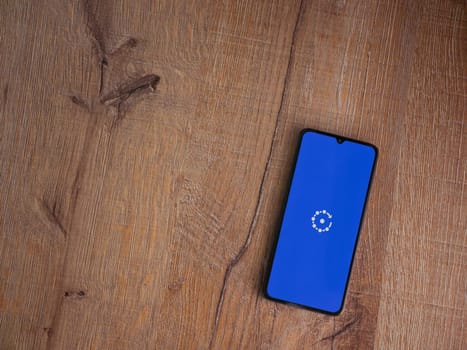 Lod, Israel - July 16,2023: Fing app launch screen on smartphone on wooden background. Top view flat lay with copy space.