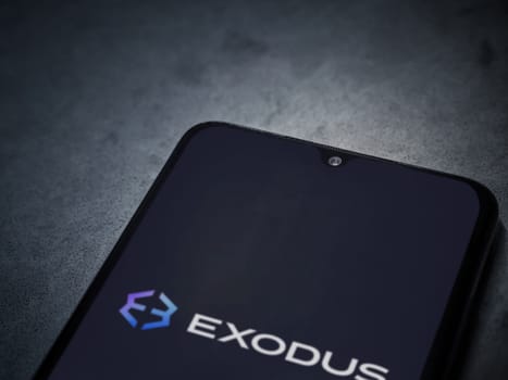 Lod, Israel - July 16,2023: Exodus app launch screen on smartphone on dark marble stone background. Top view flat lay with copy space.