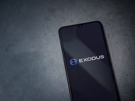 Lod, Israel - July 16,2023: Exodus app launch screen on smartphone on dark marble stone background. Top view flat lay with copy space.