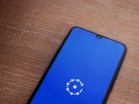 Lod, Israel - July 16,2023: Fing app launch screen on smartphone on wooden background. Top view flat lay with copy space.