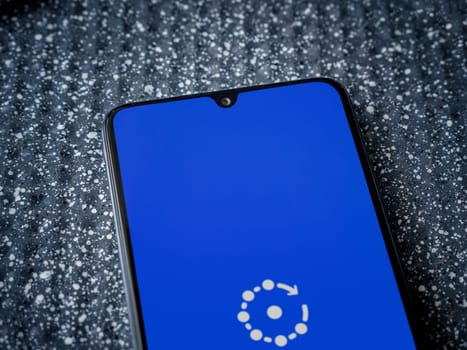 Lod, Israel - July 16,2023: Fing app launch screen on smartphone on metallic background. Close up top view flat lay.