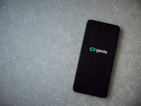 Lod, Israel - July 16,2023: Genie app launch screen on smartphone on ceramic stone background. Top view flat lay with copy space.