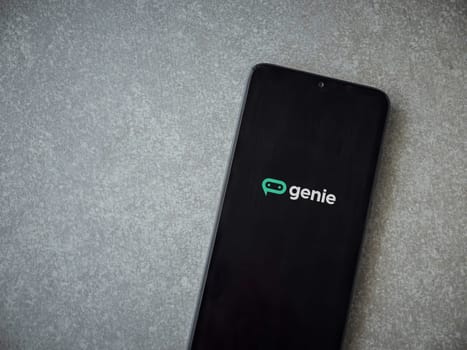 Lod, Israel - July 16,2023: Genie app launch screen on smartphone on ceramic stone background. Top view flat lay with copy space.