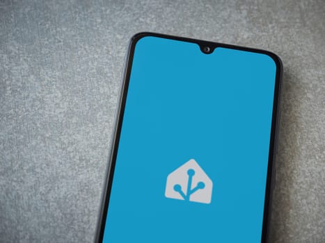 Lod, Israel - July 16,2023: Home Assistant app launch screen on smartphone on ceramic stone background. Top view flat lay with copy space.