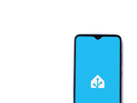 Lod, Israel - July 16,2023: Home Assistant app launch screen on smartphone on white background. Top view flat lay with copy space.
