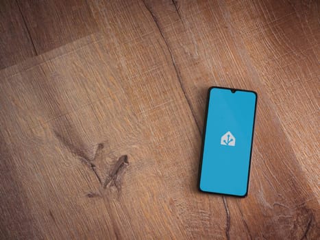 Lod, Israel - July 16,2023: Home Assistant app launch screen on smartphone on wooden background. Top view flat lay with copy space.