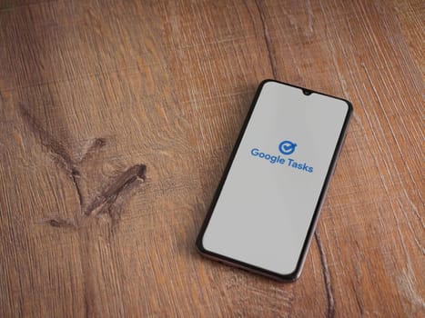 Lod, Israel - July 16,2023: Google Task app launch screen on smartphone on wooden background. Top view flat lay with copy space.