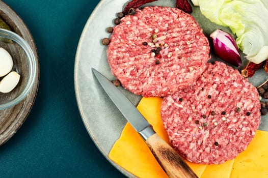 Fresh with seasoning raw minced beef steak burgers. Cooking burger. Raw steak cutlets. Wooden background.