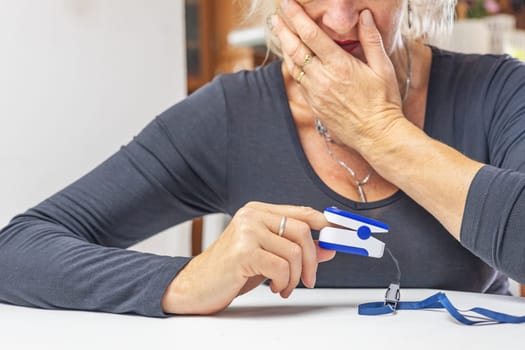 Surprised woman sadly looks at the results of measuring the heart pulse and blood oxygenation.