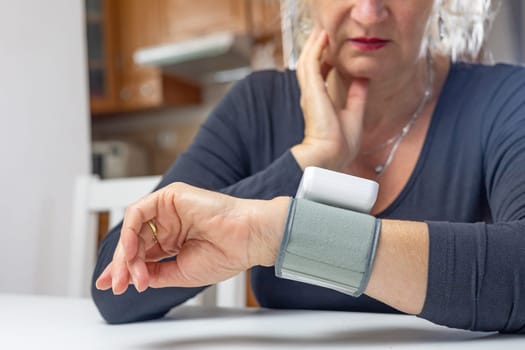 Surprised woman sadly looks at blood pressure measurement results.