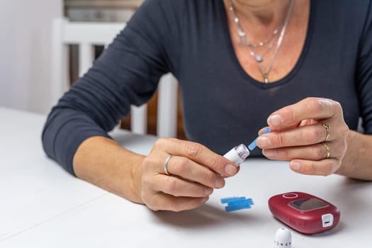 woman  is preparing blood lamcets  for measuring blood sugar level. Horizontally.