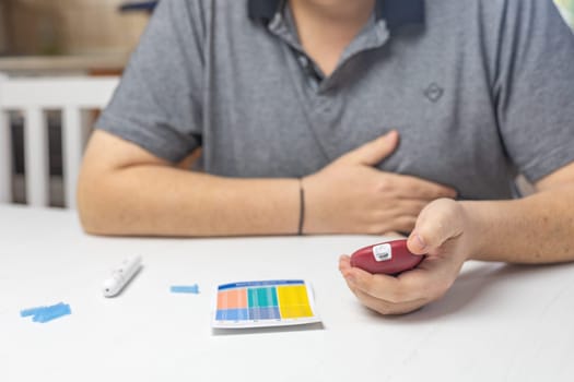 Unpleasantly surprised man looks at the results of blood sugar  level measurement. Horizontally.