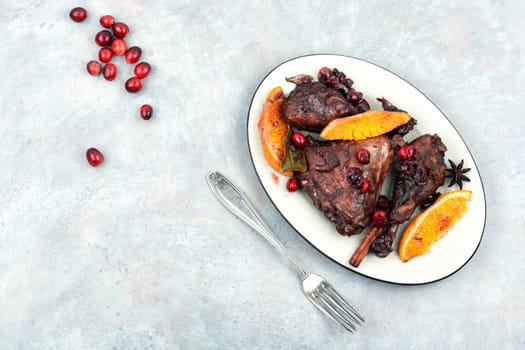 Chicken legs marinated in red wine, baked with orange and berries. Roasted chicken meat. Top view. Copy space.