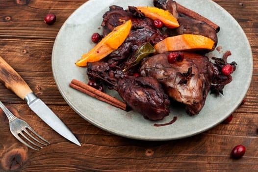 Chicken legs marinated in red wine, baked with orange and berries. Roasted chicken meat. Top view. Copy space.
