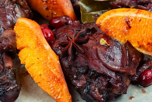 Baked chicken legs with orange and berries.