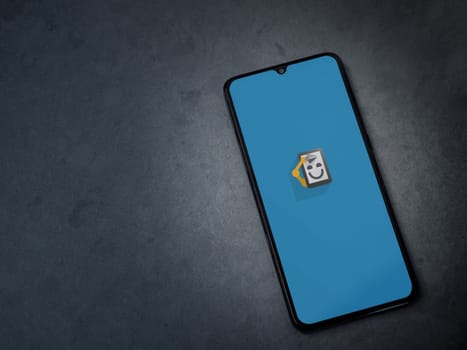 Lod, Israel - July 16,2023: Automate app launch screen on smartphone on dark marble stone background. Top view flat lay with copy space.