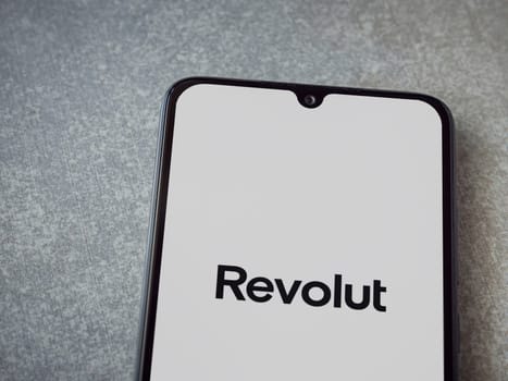 Lod, Israel - July 16,2023: Revolut app launch screen on smartphone on ceramic stone background. Top view flat lay with copy space.
