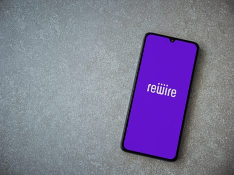 Lod, Israel - July 16,2023: Rewire app launch screen on smartphone on ceramic stone background. Top view flat lay with copy space.