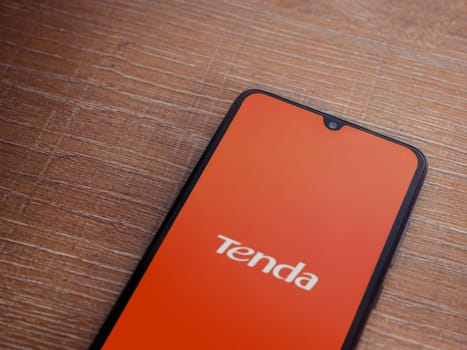 Lod, Israel - July 16,2023: Tenda Wifi app launch screen on smartphone on wooden background. Top view flat lay with copy space.