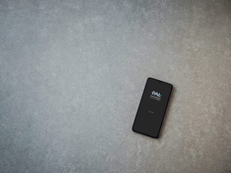 Lod, Israel - July 16,2023: PalGate app launch screen on smartphone on ceramic stone background. Top view flat lay with copy space.