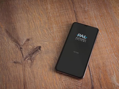 Lod, Israel - July 16,2023: PalGate app launch screen on smartphone on wooden background. Top view flat lay with copy space.
