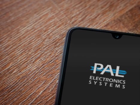 Lod, Israel - July 16,2023: PalGate app launch screen on smartphone on wooden background. Top view flat lay with copy space.