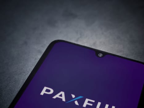 Lod, Israel - July 16,2023: Paxful app launch screen on smartphone on dark marble stone background. Top view flat lay with copy space.