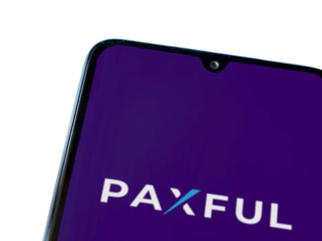 Lod, Israel - July 16,2023: Paxful app launch screen on smartphone on white background. Top view flat lay with copy space.