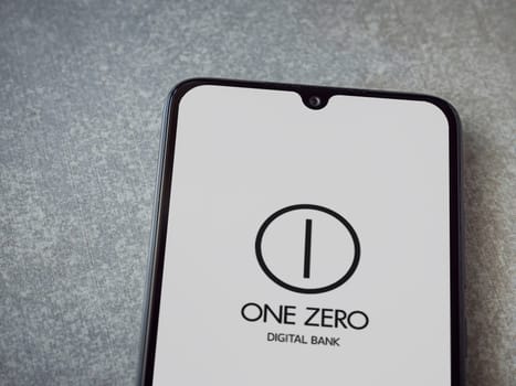 Lod, Israel - July 16,2023: One Zero app launch screen on smartphone on ceramic stone background. Top view flat lay with copy space.