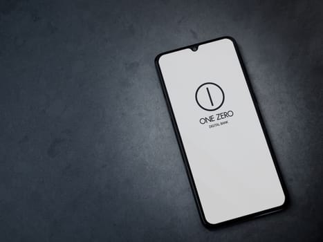 Lod, Israel - July 16,2023: One Zero app launch screen on smartphone on dark marble stone background. Top view flat lay with copy space.