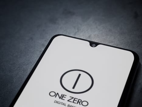 Lod, Israel - July 16,2023: One Zero app launch screen on smartphone on dark marble stone background. Top view flat lay with copy space.