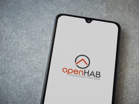 Lod, Israel - July 16,2023: openHAB app launch screen on smartphone on ceramic stone background. Top view flat lay with copy space.