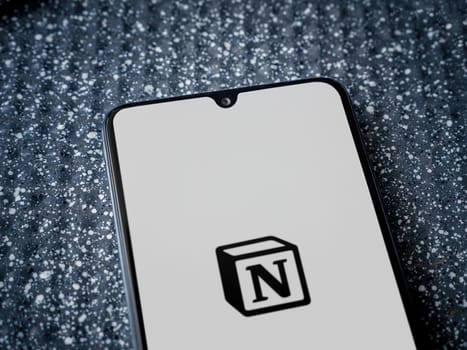 Lod, Israel - July 16,2023: Notion app launch screen on smartphone on metallic background. Close up top view flat lay.